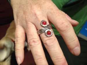 DUALITY. The ring, inspired by classical Greek art, features two carnelians. The silver band wraps around the finger three times before going off in opposite directions, where the stores are displayed.